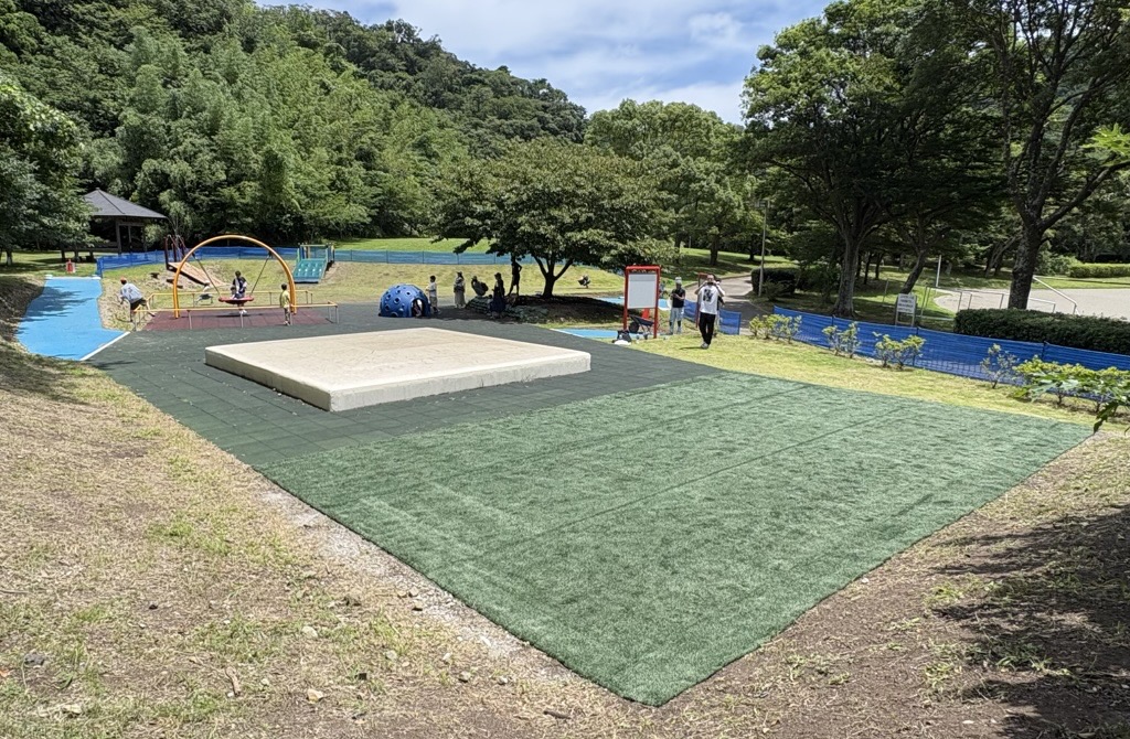 写真内の緑色のエリアのうち、手前半分ほどにペーパーターフが敷かれています
（神奈川県葉山町の南郷上ノ山公園内インクルーシブ広場にて）